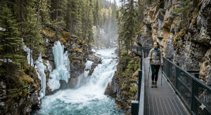 This image illustrates that traveling during the cheapest time to visit Banff (spring shoulder season) offers unique, high-value experiences like the frozen-and-thawing Johnston Canyon.